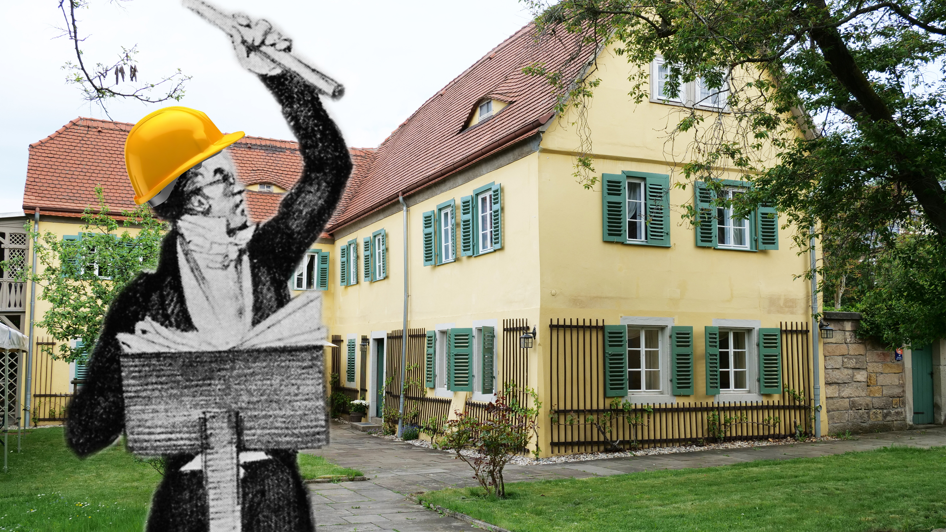 KI generiert: Das Bild zeigt eine historische Figur mit einem Bauhelm vor einem traditionellen, gelben Gebäude mit grünen Fensterläden. Die Figur scheint auf das Gebäude zu deuten und steht im Vordergrund.